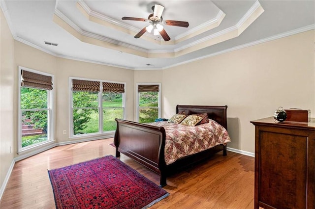 2709 Windrush Dr, Buford, GA 30518 - bedroom featuring wood finished floors, a tray ceiling, baseboards, ornamental molding, and a ceiling fan