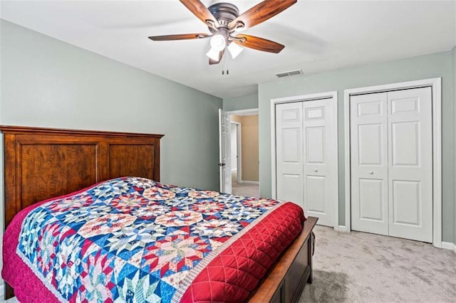 2709 Windrush Dr, Buford, GA 30518 - bedroom with light carpet, two closets, ceiling fan, and baseboards
