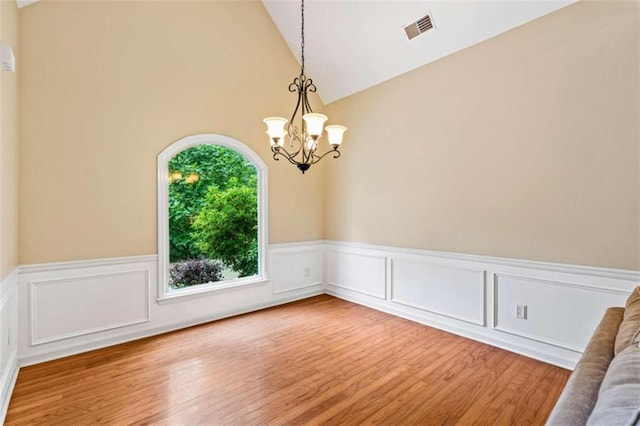 2709 Windrush Dr, Buford, GA 30518 - spare room with wood finished floors, a chandelier, wainscoting, and high vaulted ceiling
