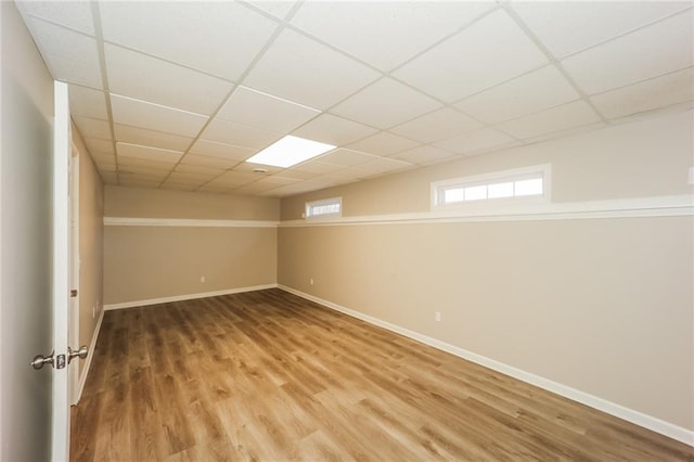 basement featuring a paneled ceiling and hardwood / wood-style floors