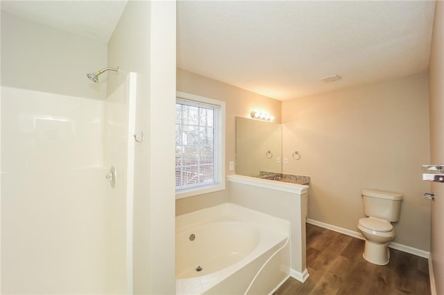 bathroom with hardwood / wood-style floors, toilet, and a bathing tub