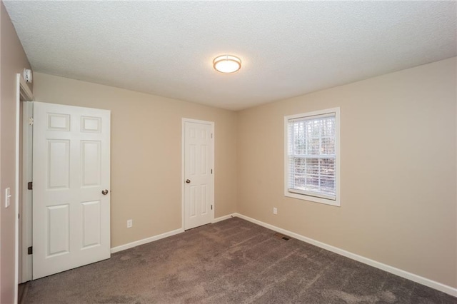 carpeted empty room featuring a textured ceiling