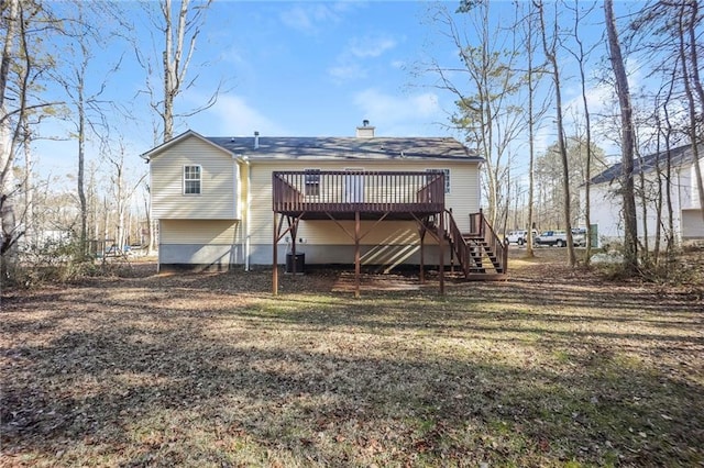 back of house with a deck and a lawn