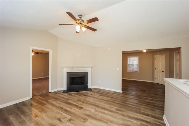 unfurnished living room with wood-type flooring, ceiling fan, and vaulted ceiling