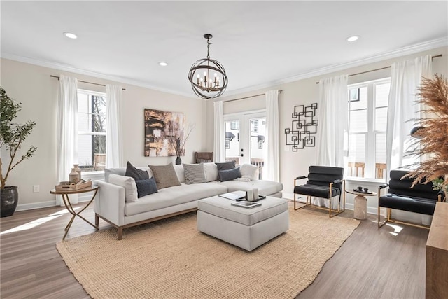 living room featuring recessed lighting, an inviting chandelier, ornamental molding, wood finished floors, and baseboards