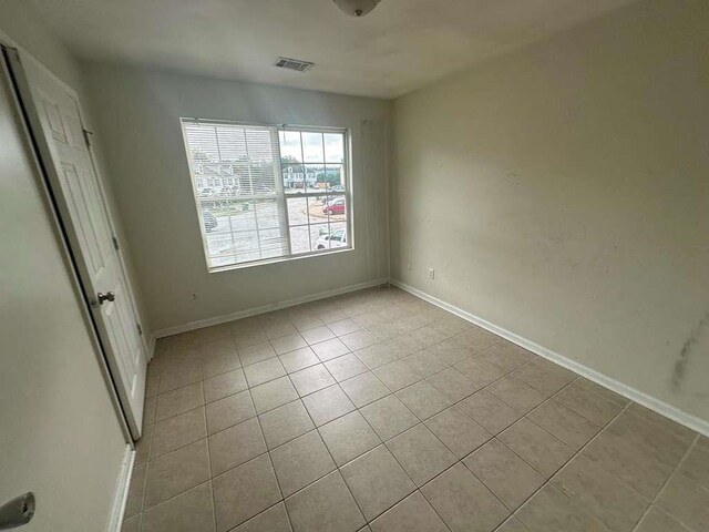 spare room featuring light tile patterned flooring