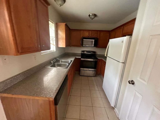 kitchen featuring light tile patterned floors, stainless steel appliances, and sink