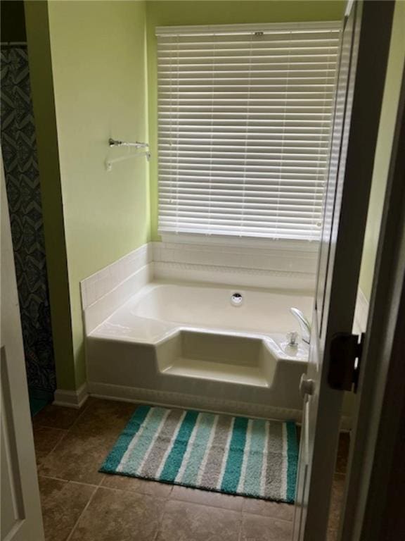 bathroom with tile patterned flooring and a tub