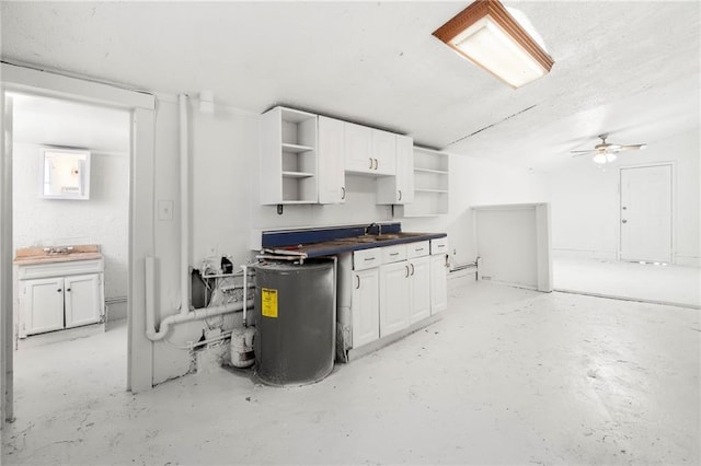 kitchen with sink, water heater, and white cabinets