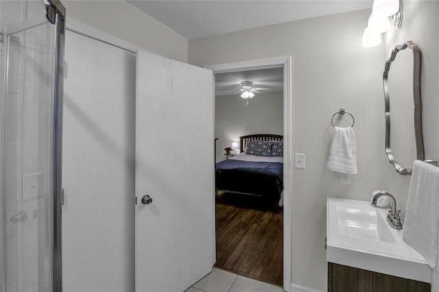 bathroom with ceiling fan, tile patterned flooring, vanity, and walk in shower