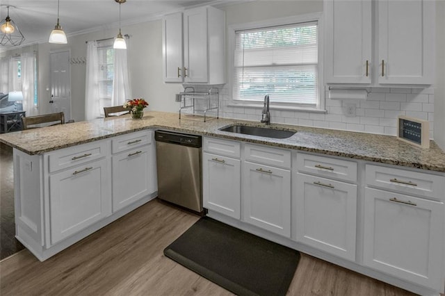 kitchen with stainless steel dishwasher, sink, decorative light fixtures, light hardwood / wood-style flooring, and white cabinetry