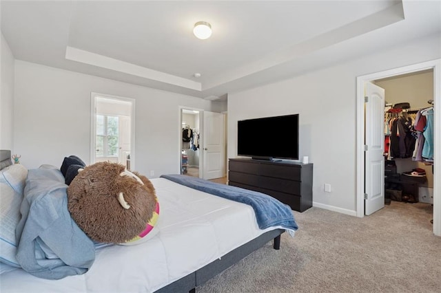 81 Birch River Pointe, Dallas, GA 30132 - carpeted bedroom featuring a walk in closet, a raised ceiling, a closet, baseboards, and ensuite bathroom