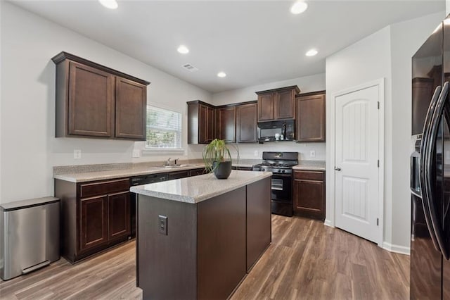 81 Birch River Pointe, Dallas, GA 30132 - kitchen with black appliances, a sink, dark brown cabinets, wood finished floors, and recessed lighting