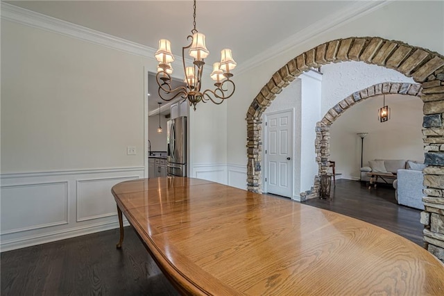 113 Gold Bridge Xing, Canton, GA 30114 - dining space featuring a chandelier, arched walkways, dark wood-type flooring, ornamental molding, and wainscoting