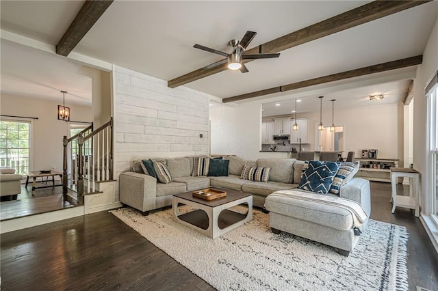 113 Gold Bridge Xing, Canton, GA 30114 - living room featuring dark wood-style flooring, beamed ceiling, ceiling fan, a chandelier, and stairs