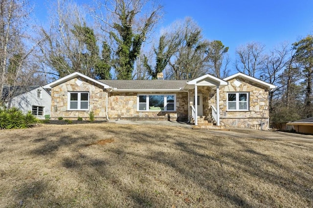 view of front of house with stone siding, a chimney, and a front yard