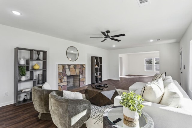 living area with dark wood-style floors, a fireplace, visible vents, and recessed lighting