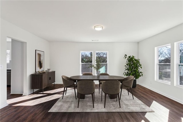 dining room with dark wood finished floors, visible vents, and baseboards