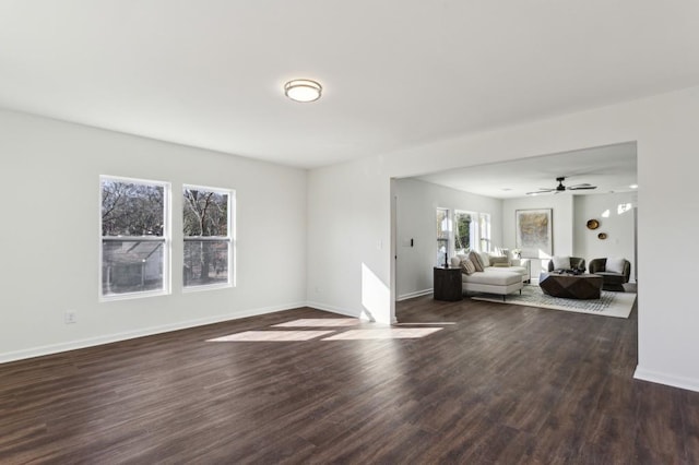 unfurnished living room with dark wood-style floors and baseboards