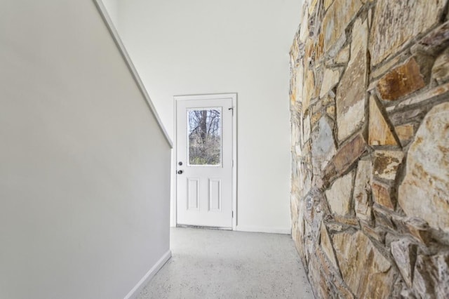 hall with baseboards and speckled floor