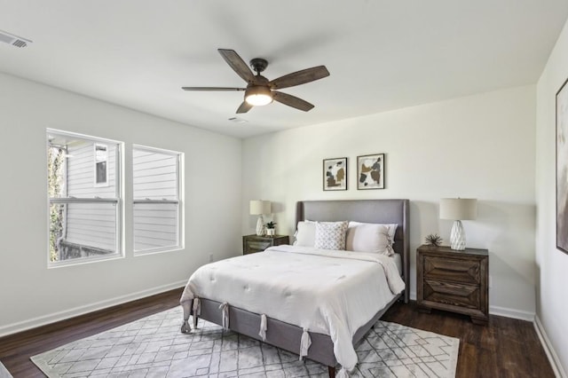 bedroom with ceiling fan, wood finished floors, visible vents, and baseboards