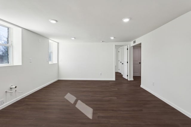 unfurnished room with dark wood-style floors, visible vents, baseboards, and recessed lighting