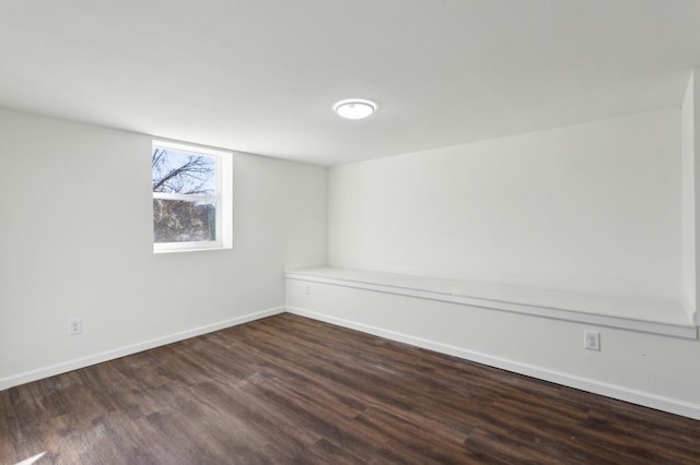 spare room featuring dark wood finished floors and baseboards