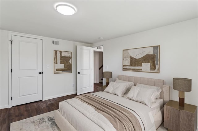 bedroom with visible vents, baseboards, and wood finished floors