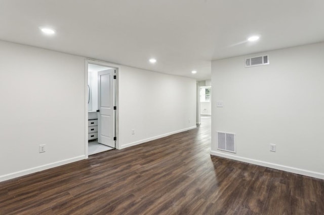 finished basement featuring dark wood-style floors, baseboards, visible vents, and recessed lighting