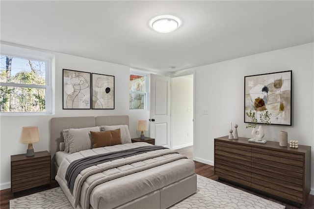 bedroom with baseboards and dark wood-style flooring