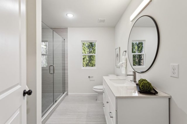 bathroom featuring a stall shower, baseboards, visible vents, toilet, and vanity