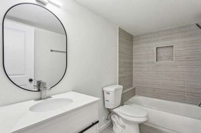 bathroom featuring toilet, bathtub / shower combination, baseboards, and vanity