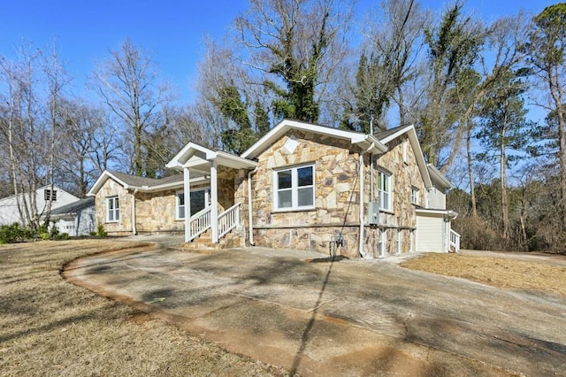 view of front facade with stone siding and concrete driveway