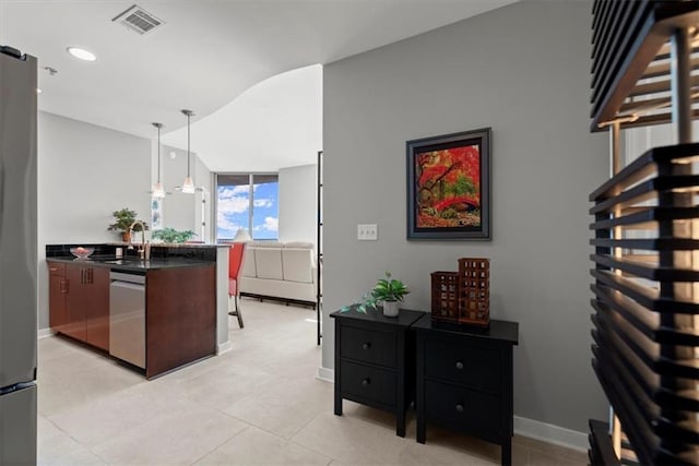 kitchen featuring stainless steel appliances, sink, light tile patterned floors, and decorative light fixtures