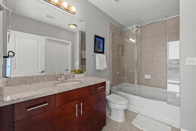 full bathroom with vanity, tile patterned floors, shower / bath combination with glass door, and toilet