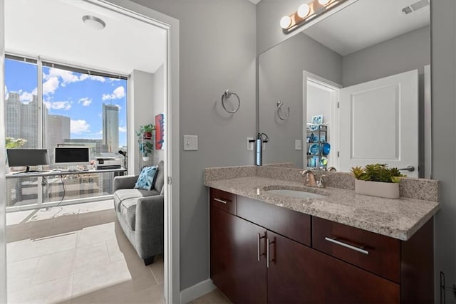 bathroom featuring tile patterned flooring, vanity, and a wall of windows