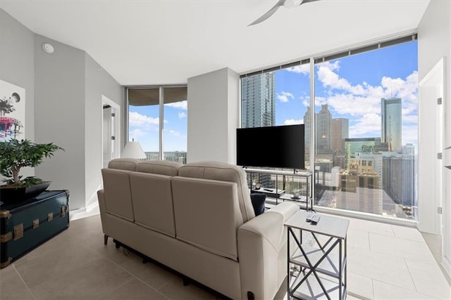 tiled living room featuring expansive windows and ceiling fan