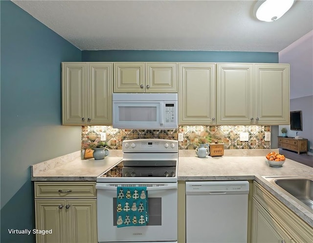 kitchen featuring white appliances, light countertops, backsplash, and a sink