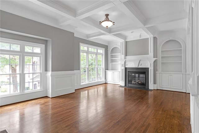 unfurnished living room with a wealth of natural light, built in features, beam ceiling, and dark hardwood / wood-style flooring