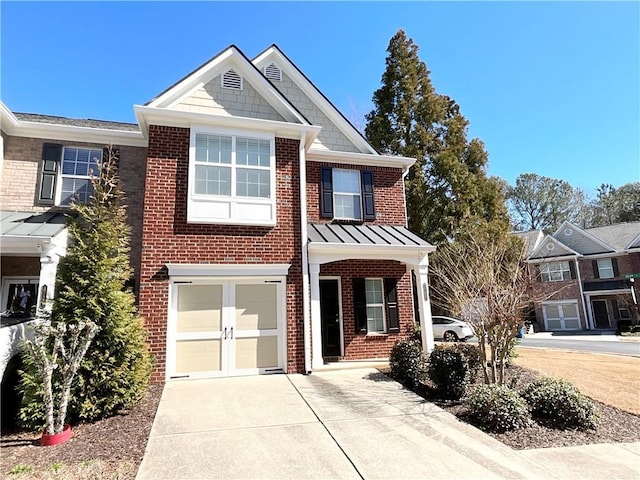 view of front of property with a garage, concrete driveway, metal roof, a standing seam roof, and brick siding