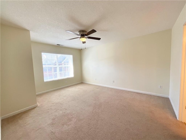 unfurnished room featuring ceiling fan, a textured ceiling, light carpet, visible vents, and baseboards