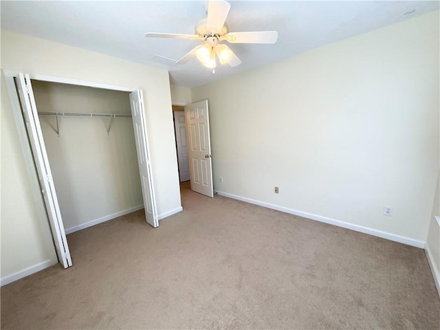 unfurnished bedroom featuring baseboards, ceiling fan, a closet, and light colored carpet