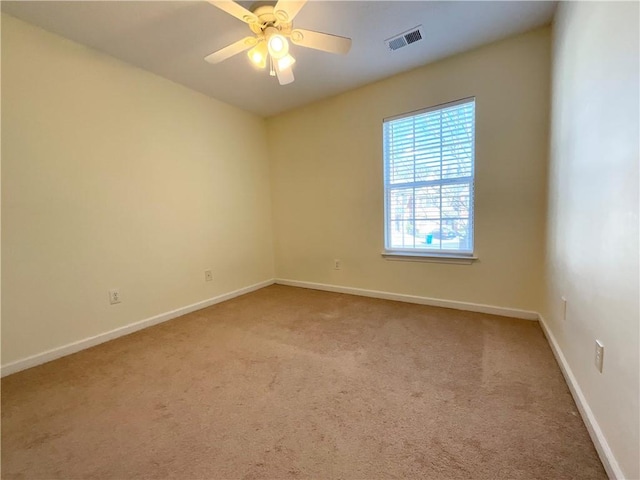 spare room featuring visible vents, carpet floors, a ceiling fan, and baseboards