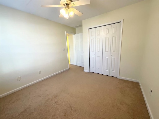 unfurnished bedroom featuring a closet, carpet flooring, a ceiling fan, and baseboards