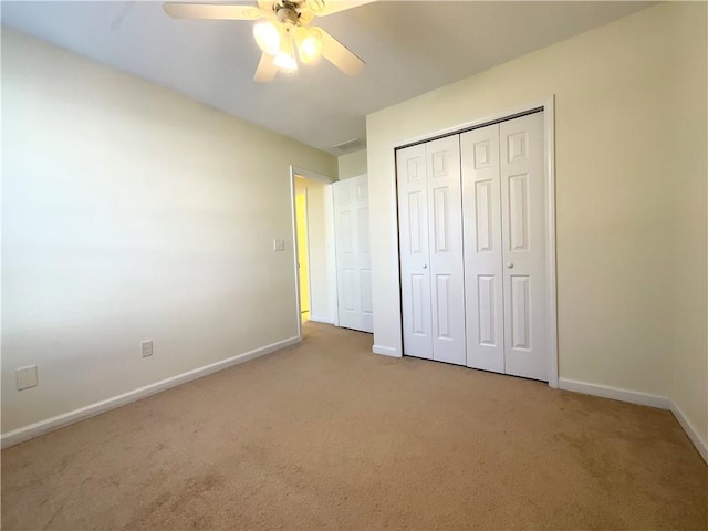 unfurnished bedroom featuring visible vents, baseboards, a ceiling fan, carpet floors, and a closet