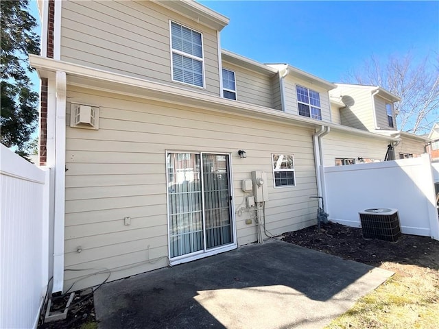 rear view of house featuring cooling unit, fence, and a patio