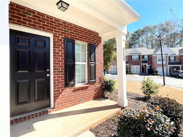 doorway to property with a residential view and brick siding