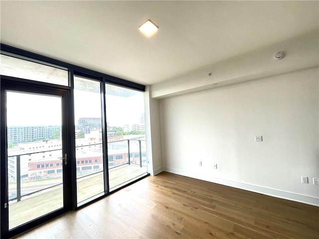 788 W Marietta St NW Unit 512, Atlanta, GA 30318 - spare room with wood finished floors, a wall of windows, a smoke detector, and a view of city