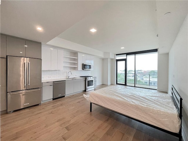788 W Marietta St NW Unit 512, Atlanta, GA 30318 - bedroom featuring high end refrigerator, light wood-style flooring, access to exterior, a wall of windows, and recessed lighting