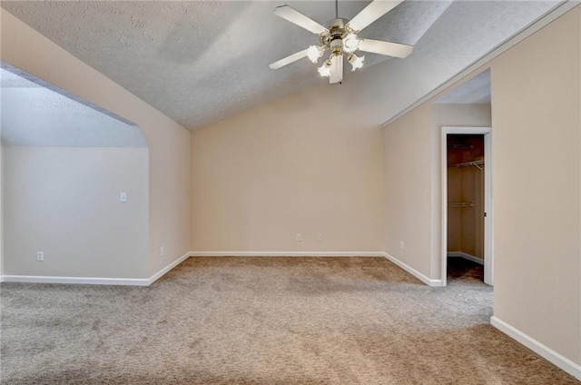 additional living space with lofted ceiling, carpet, ceiling fan, baseboards, and a textured ceiling